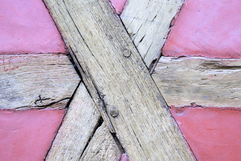 Detail eines Fachwerkhauses, Putz: pink, Holz: hellgrau
