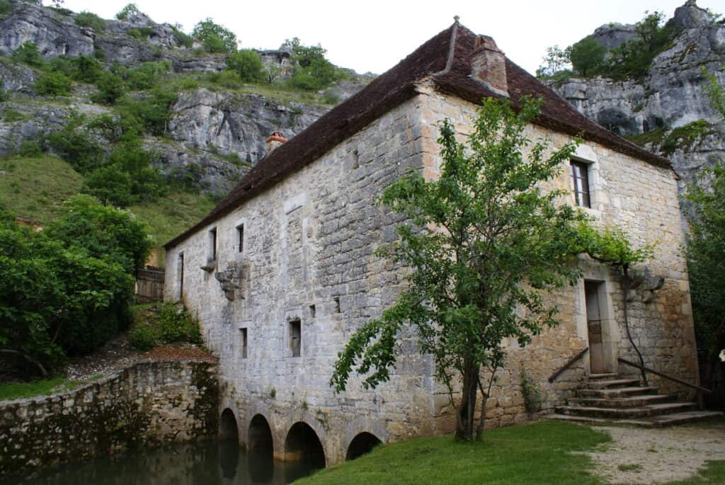 Mittelalterliche Wassermühle mit hohen Felsen