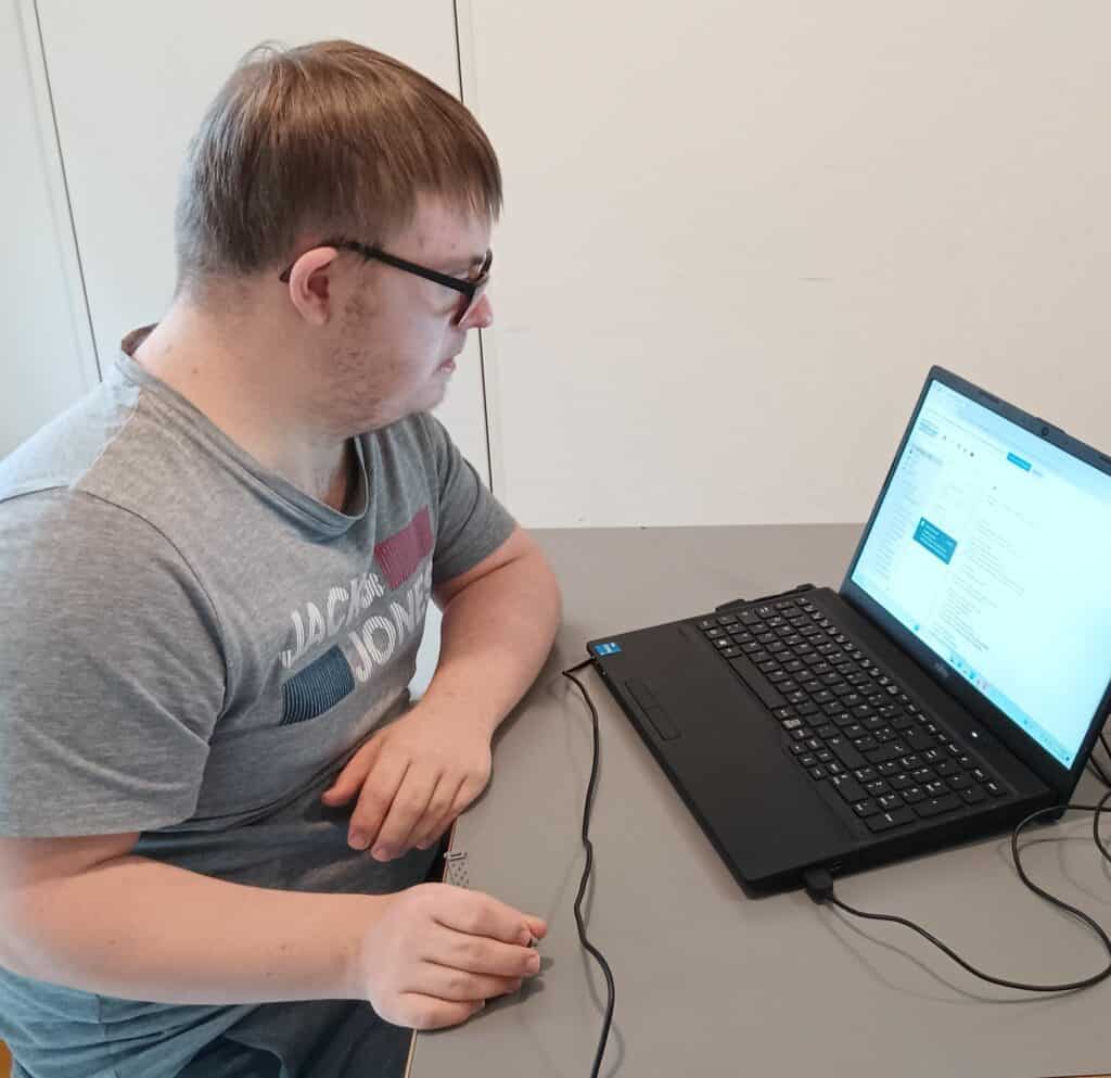 Junger Mann mit Brille vor einem PC