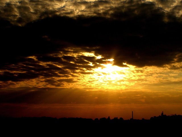 Sonnenuntergang mit dicker, dunkler Wolke