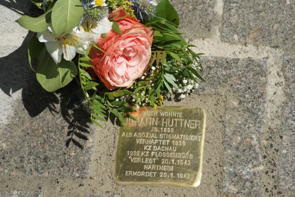 Verlegter Stolperstein mit Blumenstaruß